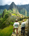 A couple standing in front of Machu Picchu wearing our Explore Peru shirts