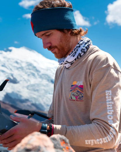 A traveler wearing one of our Explore Peru shirts in front of a snowy mountain in Peru