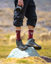 A photographer wearing our condor socks. There are alpacas in the background