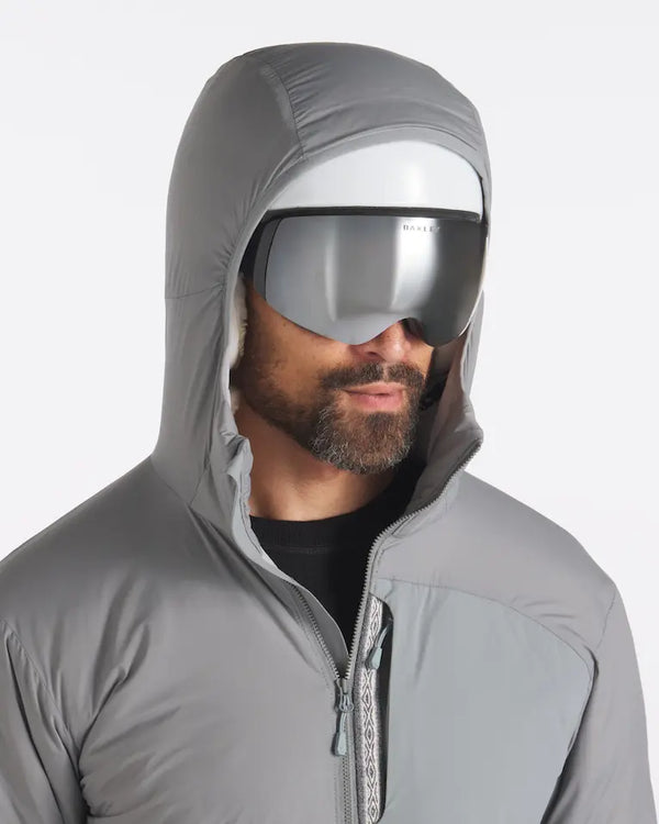 Man in Ski Helmet and Goggles Wearing Apu Hooded Lightweight Puffer in Storm / Grey – PAKA Apparel