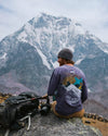 A man wearing a purple Explore Peru long sleeve in front of the Ausangate mountain