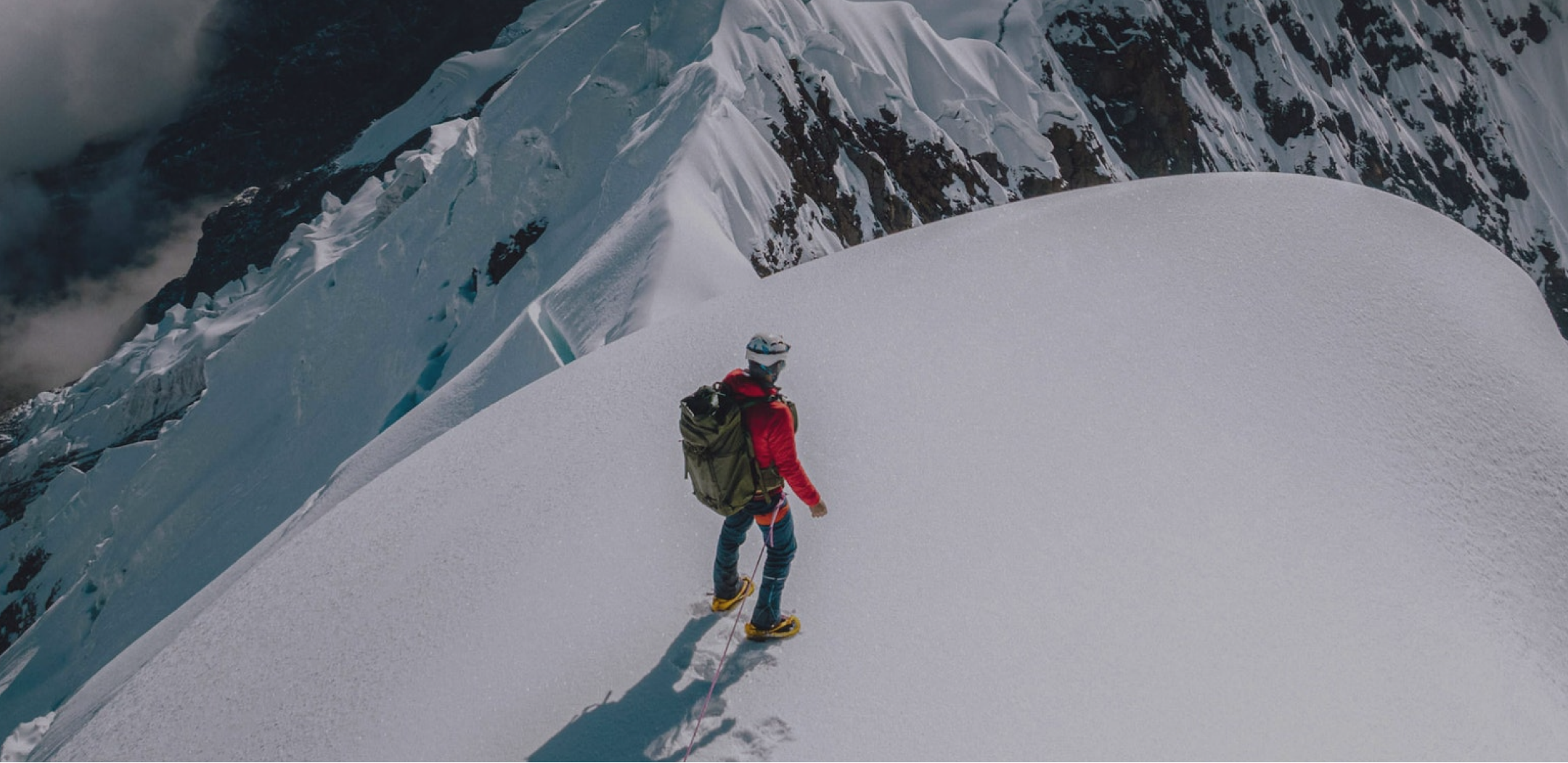 Climber on Peak of Snowy Mountain in Red Apu Puffer Jacket – PAKA Apparel