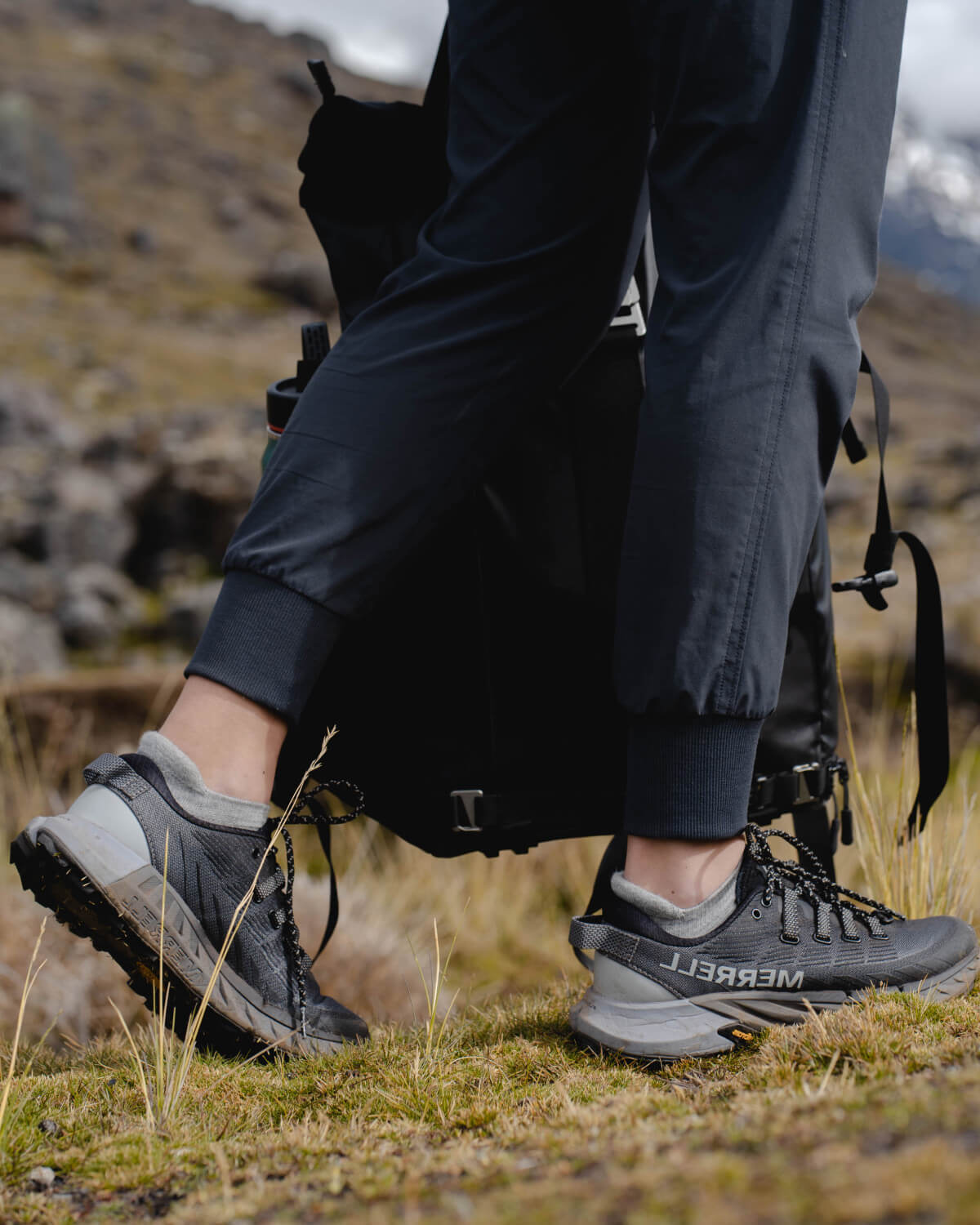 Woman backpacking through mountain wearing light grey alpaca ankle socks