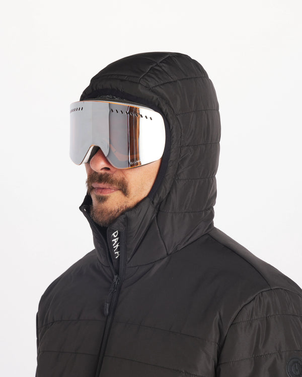Male Model Wearing Ski Goggles with Hood Up in Apu Matte Black Men’s Breathable Midweight Puffer Jacket with Natural Fiber Insulation  – PAKA Apparel