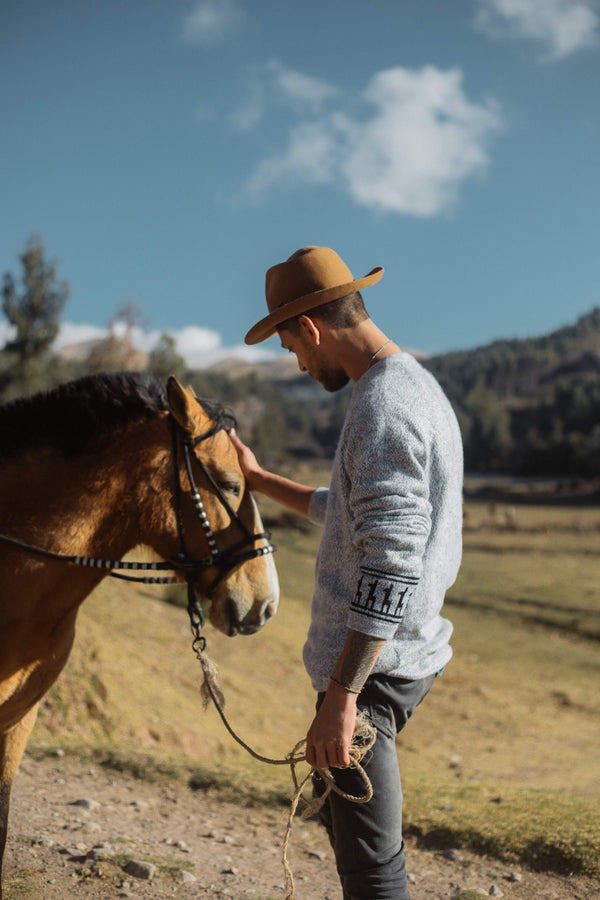 Male Cowboy petting horse in the Costa