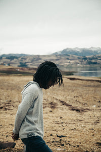 Man Wearing The Hoodie Light Grey Alpaca Wool Hooded Knit Sweater in Front of Lake and Mountains in Chinchero, Peru – PAKA Apparel