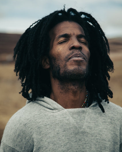 Meditative Man with Eyes Closed Wearing The Hoodie Light Grey Sustainable Knit Hoodie Sweater in Chinchero, Peru – PAKA Apparel