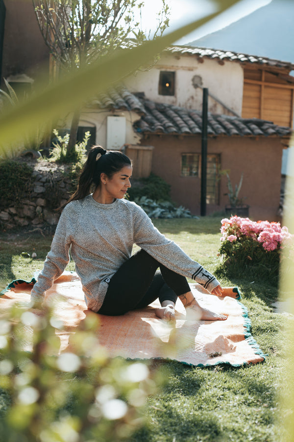Woman Model doing yoga in the Costa alpaca sweater by Paka Apparel