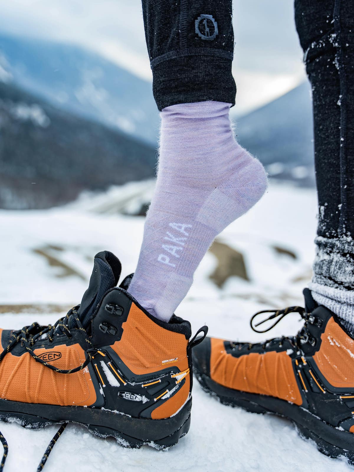 Lavender alpaca wool alpaca socks on model pulling on boots