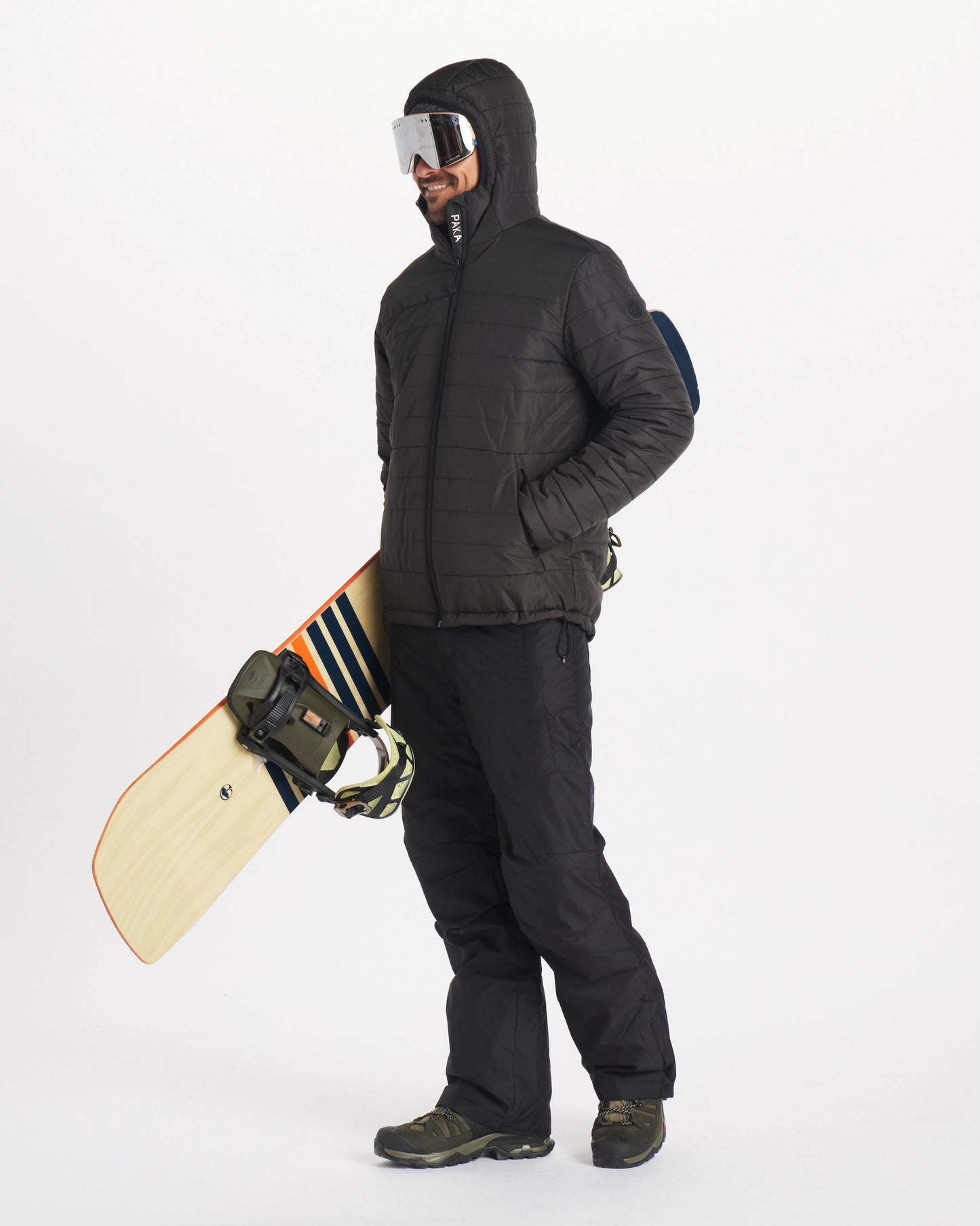 Man in black mens jacket holding a snowboard and wearing goggles 